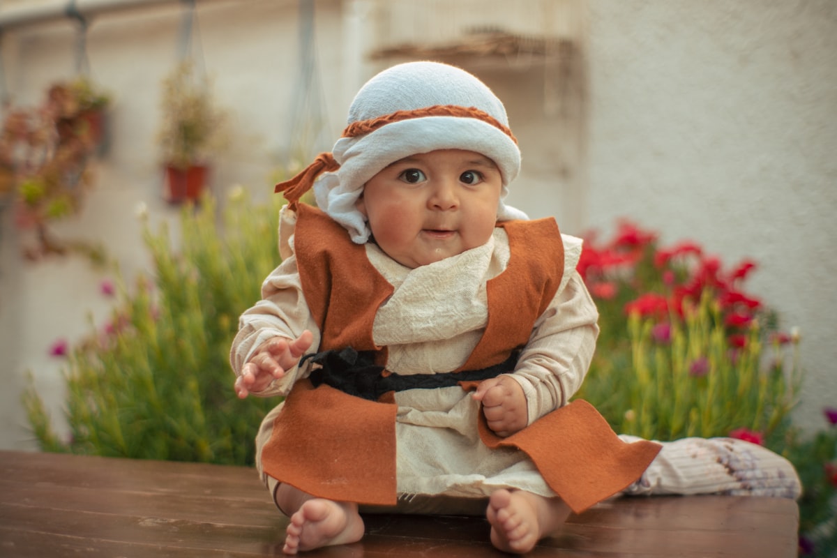 a baby sitting on a table related to Galactic Dreams: A Guide to Baby Bedding Inspired by a Galaxy Far, Far Away