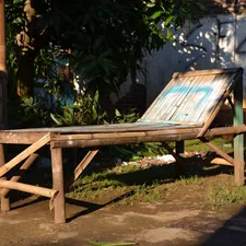 A bamboo chair is placed outdoors in the sun. related to Your Bronze Oasis Awaits: Tanning Beds for Sale Near Me