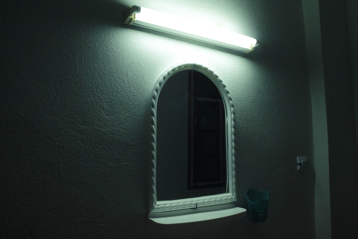 a bathroom with a mirror and a light on the wall related to Light Valance Molding: A Comprehensive Guide