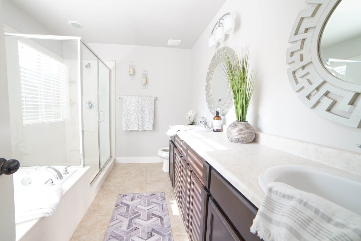 a bathroom with a sink, mirror, and bathtub related to Elevating Bathroom Decor: 3 Key Considerations for Bathroom Curtain Valances
