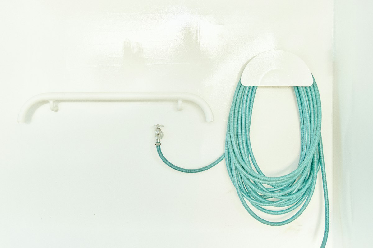 A bathroom with a toilet and a shower head related to The Ultimate Guide to Bidet Toilet Attachments: Revolutionizing Your Bathroom Experience
