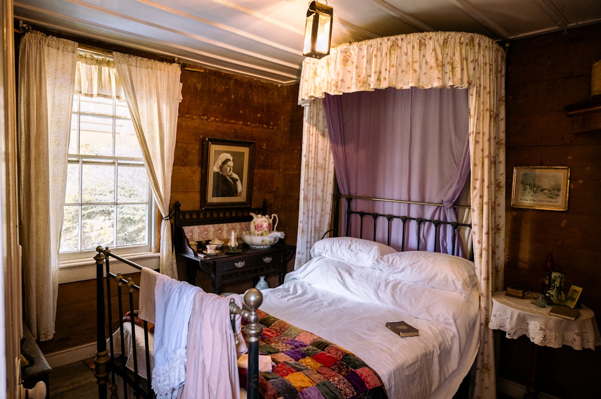 a bed in a room with a canopy over it related to Metal Canopy Bed: Revolutionizing Sleep