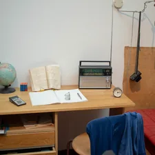 a bed room with a bed a desk and a radio related to Maximizing Space: Innovative Ideas for Combining Bed and Desk