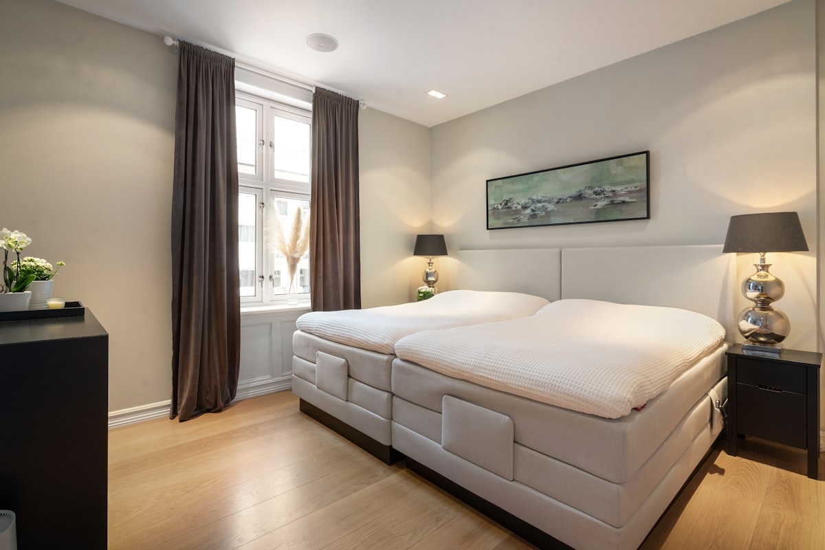 A bed room with a neatly made bed and a night stand related to Find Your Perfect Sleep, Redefined: Twin XL Bed In A Bag