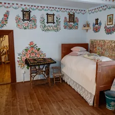 a bed room with a neatly made bed and a table related to Discover the Charm of Eureka Springs Bed and Breakfast