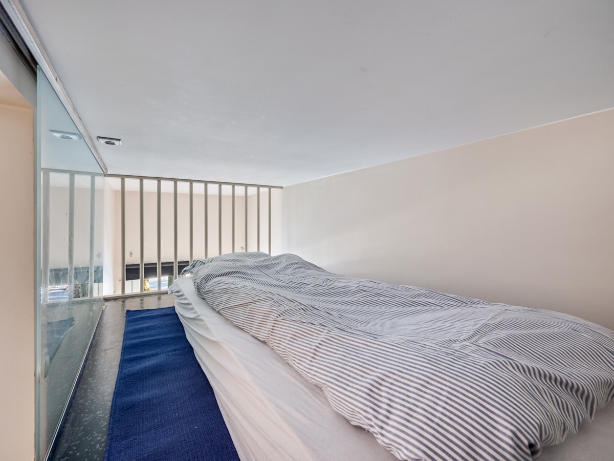 A bed sitting in a bedroom next to a window related to The Ultimate Twin Loft Bed with Slide Guide