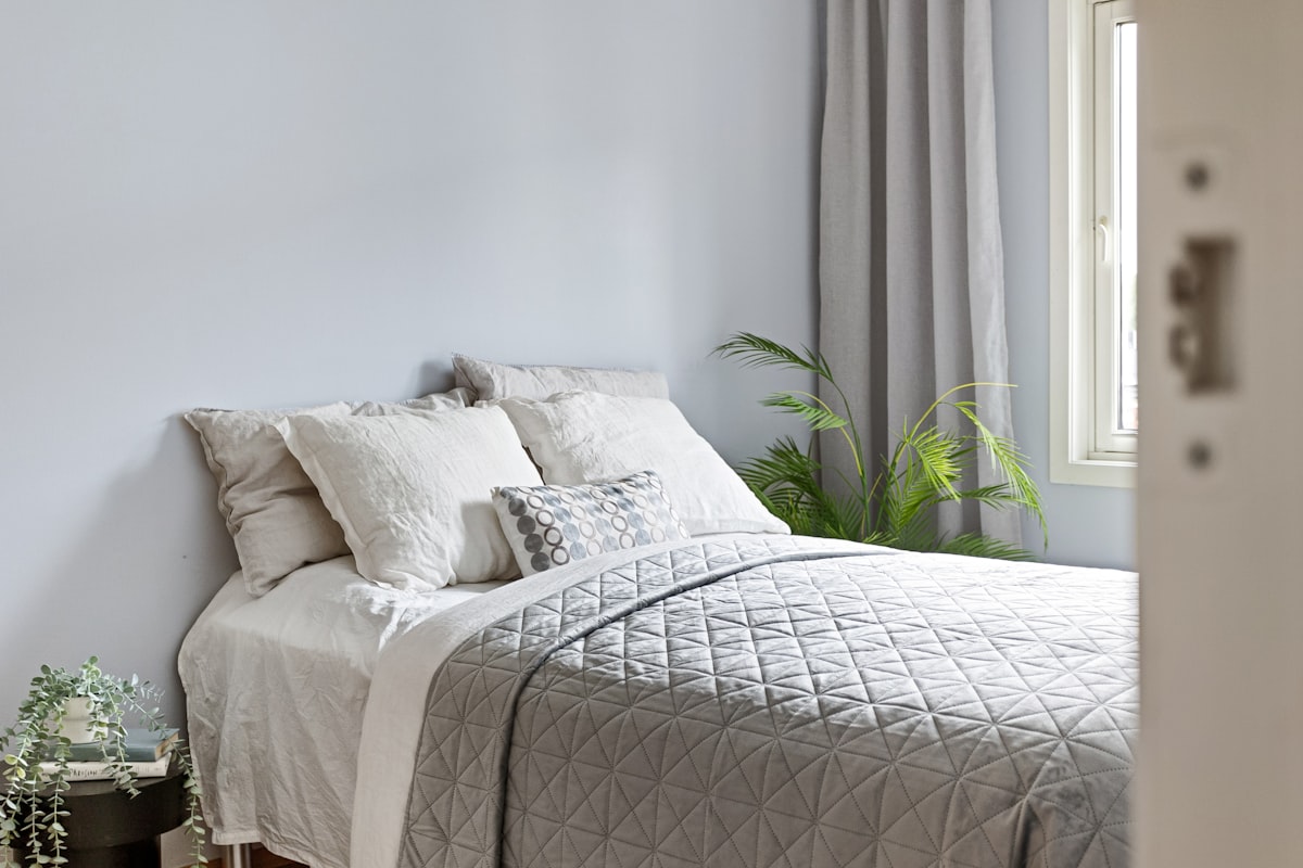 A bed sitting in a bedroom next to a window related to Toile Bedspreads and Coverlets: Comprehensive Guide