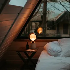 a bed sitting under a window next to a night stand related to Cozy Nights Ahead: Elevating Home Decor with Quilts & Coverlets Bedding