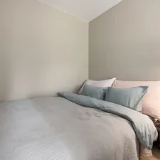 A bed sitting under a window next to a wooden floor related to Everything You Need to Know About Small Double Beds