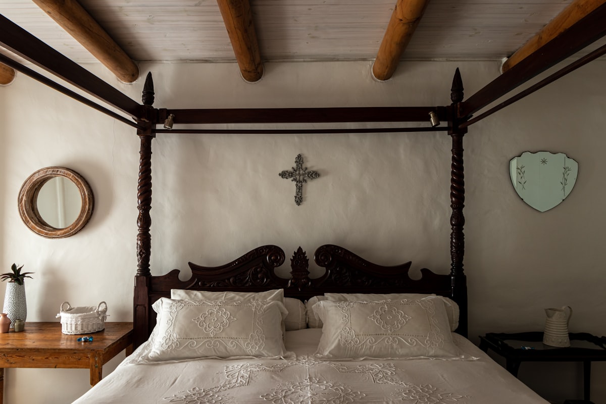 A bed with a cross on the wall above it related to Elegance Amidst Darkness: A Journey into Gothic Bed Frames