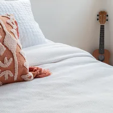 a bed with a white comforter and a guitar on the wall related to Tapestry Coverlet Bedding