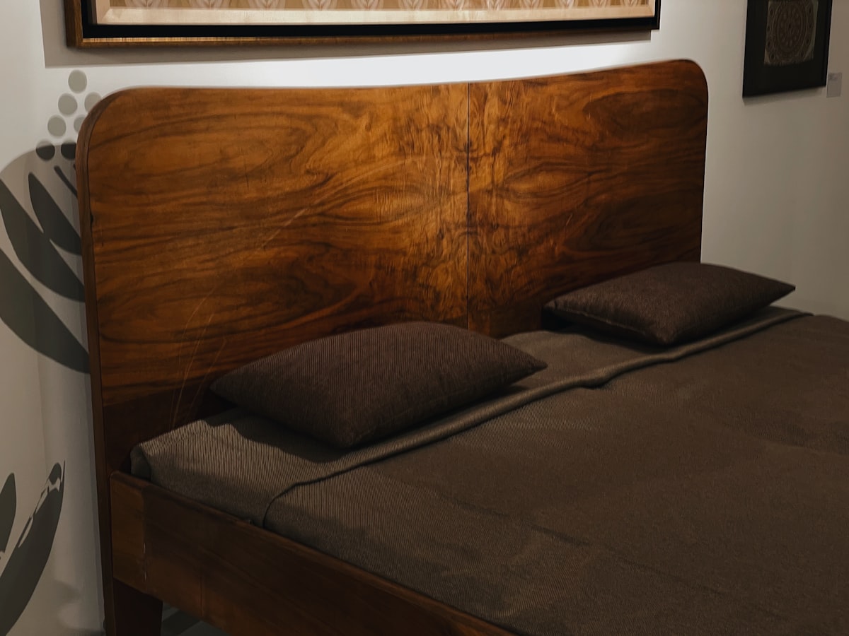 a bed with a wooden headboard and brown sheets related to Sustainable Sleep: Unleashing the Beauty of Wooden Bed Frames