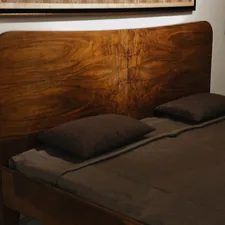 a bed with a wooden headboard and brown sheets related to Sustainable Sleep: Unleashing the Beauty of Wooden Bed Frames