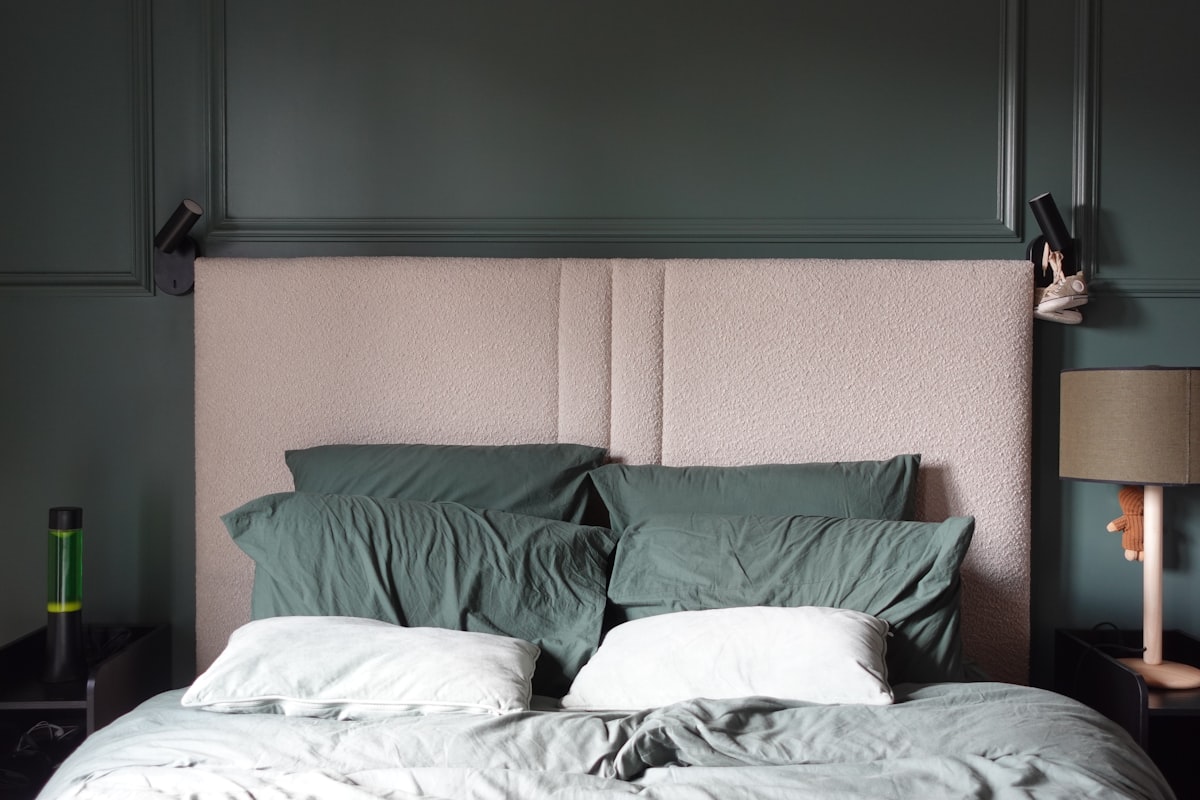 A bed with pillows and a lamp on a nightstand. related to The Luxurious Touch of Cotton Matelasse Coverlets: Elevating Your Home Decor