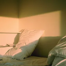 a bed with white sheets and pillows in a room related to Elevate Your Sleeping Experience: Make Your Bed Higher