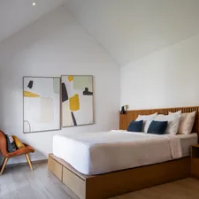 A bedroom with a bed and a chair in it related to Elevate Your Hotel's Style with High-Quality Coverlets