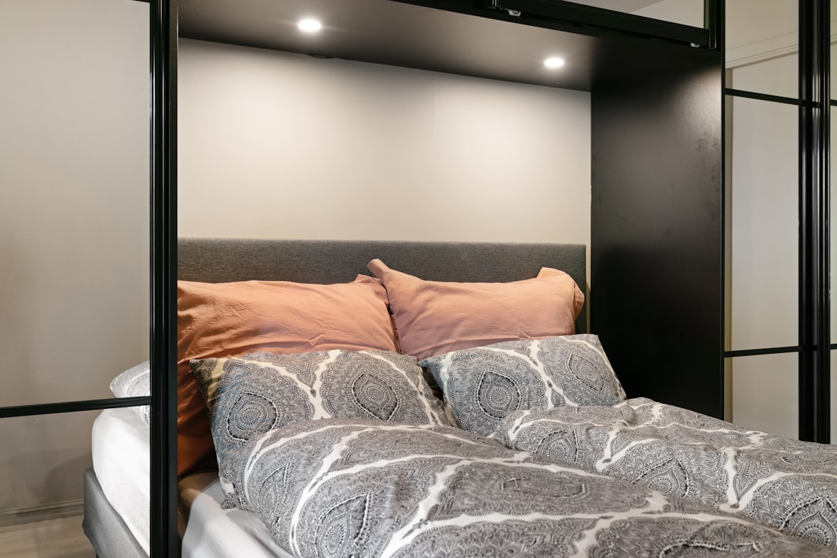 A bedroom with a bed and a mirror on the wall related to The Ultimate Guide to Pull Out Beds
