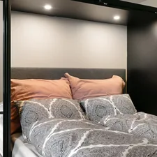 A bedroom with a bed and a mirror on the wall related to The Ultimate Guide to Pull Out Beds