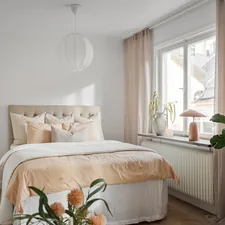 A bedroom with a bed and a plant in the corner related to Leirvik Bed Frame Review: A Stylish and Affordable Choice for Your Bedroom