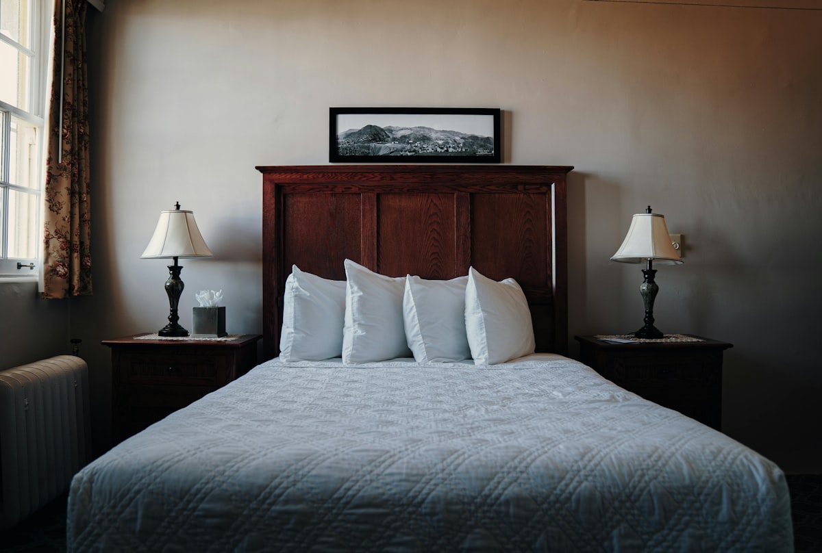 A bedroom with a bed and two lamps related to The Ultimate Guide to King Bed Sizes