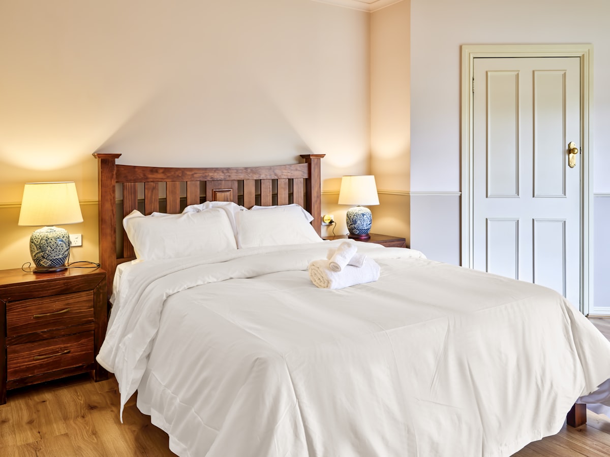 A bedroom with a bed and two lamps related to Twin White Coverlet: A Comprehensive Guide