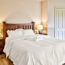 A bedroom with a bed and two lamps related to Twin White Coverlet: A Comprehensive Guide