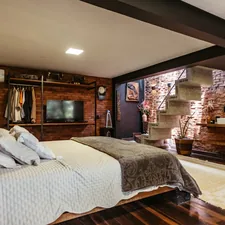 A bedroom with a bed, dresser and mirror related to Maximizing Space: The Ultimate Guide to Loft Beds with Stairs and Desk Solutions