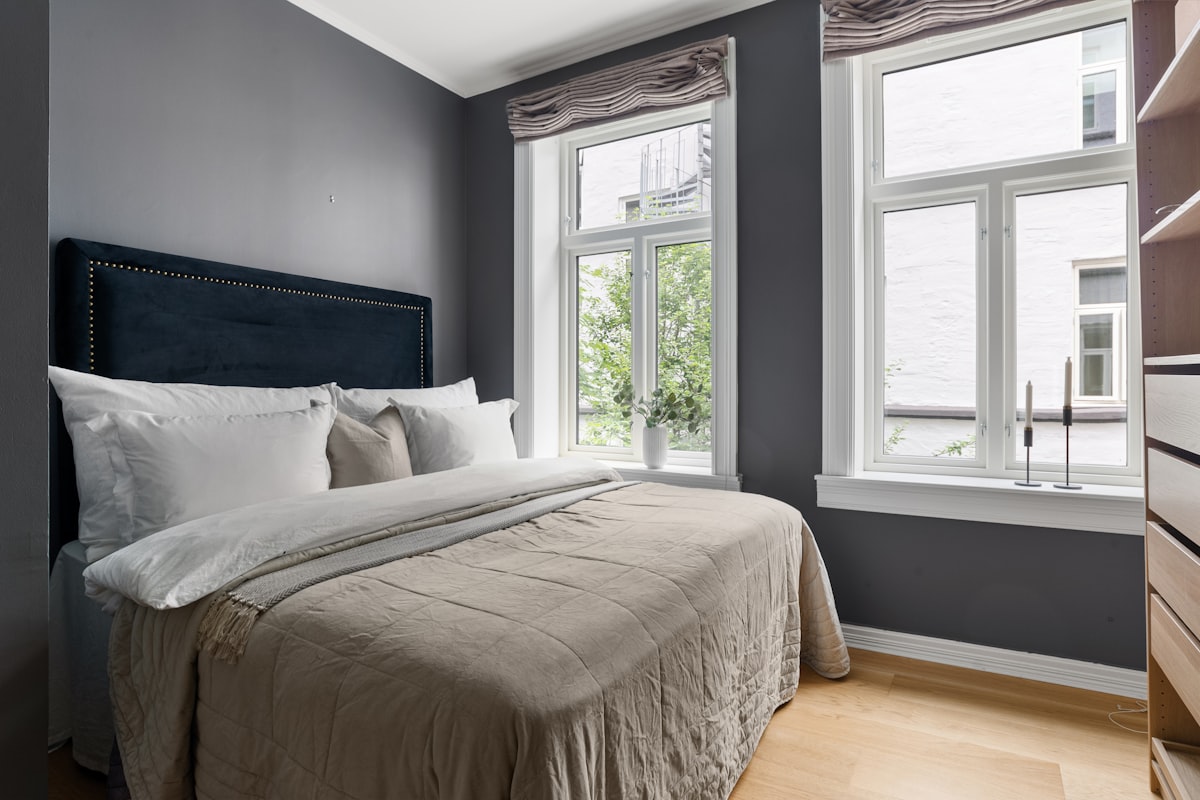 A bedroom with a bed, dresser, and two windows related to Grey Bed Valance: Add Sophisticated Style to Your Bedroom