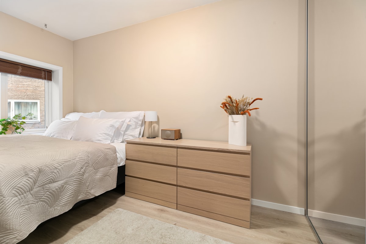 A bedroom with a bed, dresser, and window related to Classic Chic: Finding the Perfect Bedroom Sets with Drawers Under Bed