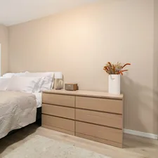 A bedroom with a bed, dresser, and window related to Classic Chic: Finding the Perfect Bedroom Sets with Drawers Under Bed