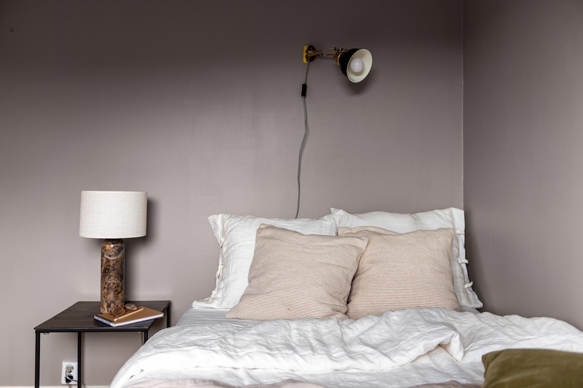 A bedroom with a bed, nightstand and lamp related to Elevate Your Bedroom with Gray Linen Bedding