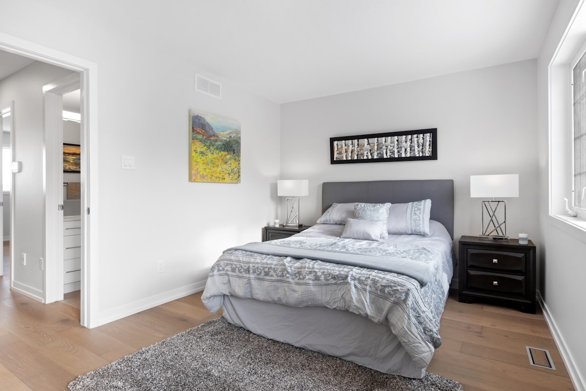 a bedroom with a bed, nightstands and a painting on the wall related to Elevate Your Bedroom with Grey and Pink Bedding