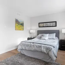 a bedroom with a bed, nightstands and a painting on the wall related to Elevate Your Bedroom with Grey and Pink Bedding