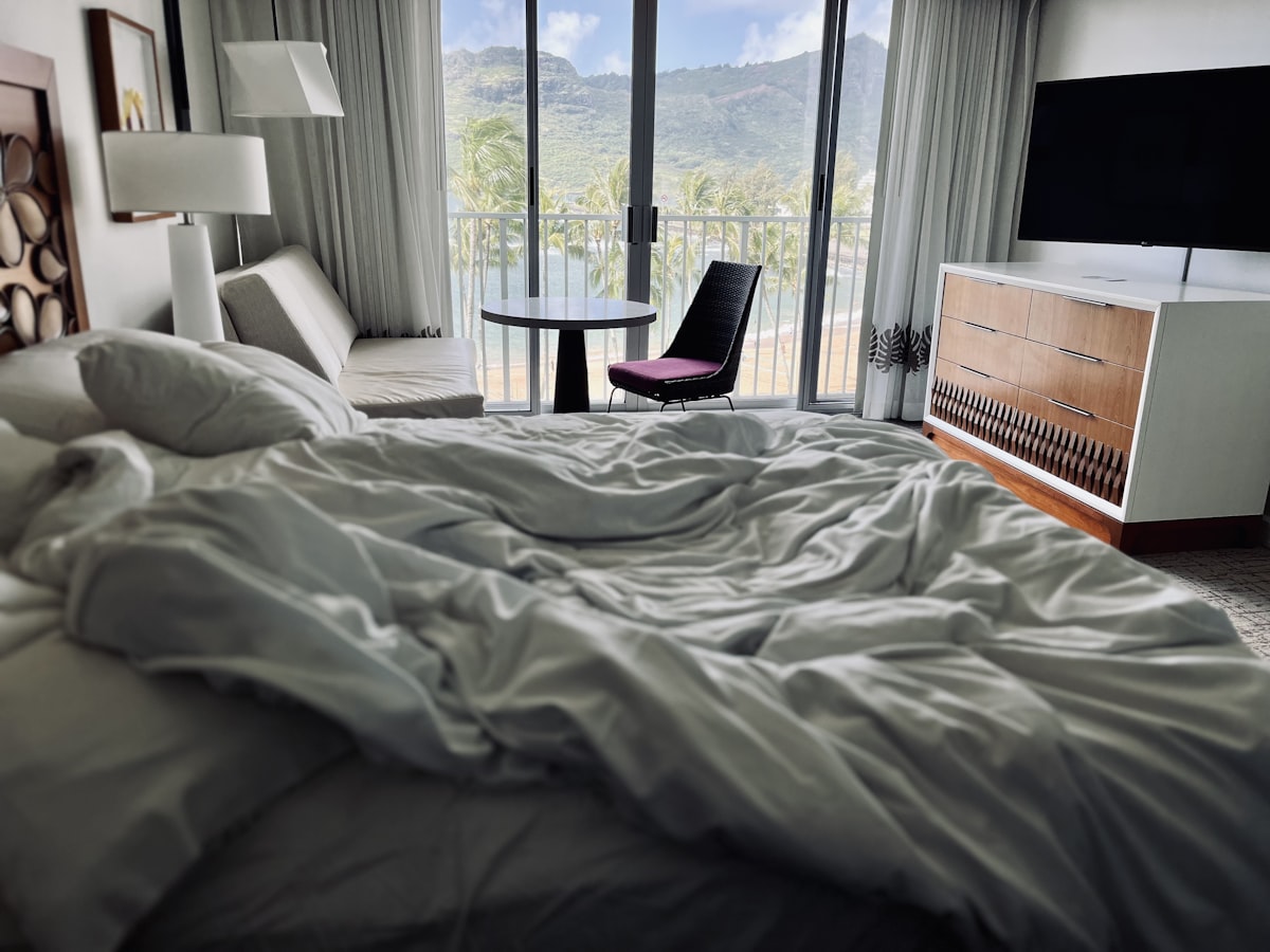 a bedroom with a large bed and a balcony related to Sleeping in Style: The Joy of Rollaway Beds