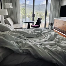 a bedroom with a large bed and a balcony related to Sleeping in Style: The Joy of Rollaway Beds