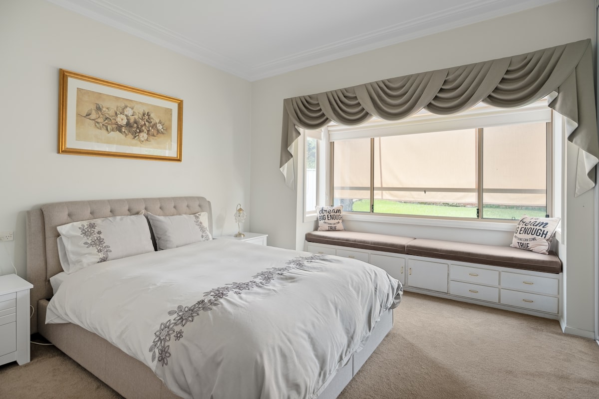 A bedroom with a large bed and a window related to The Ultimate Guide to Tier and Valance Sets: Elevating Your Windows and Rooms