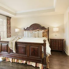 A bedroom with a large bed and a wooden dresser related to King Size Matelasse Coverlet: Elegant Bedding for a Regal Sleep