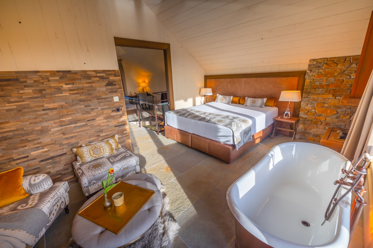 a bedroom with a tub and a bed related to Cozying Up with Pottery Barn Bed and Bath Essentials