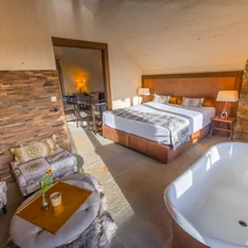 a bedroom with a tub and a bed related to Cozying Up with Pottery Barn Bed and Bath Essentials