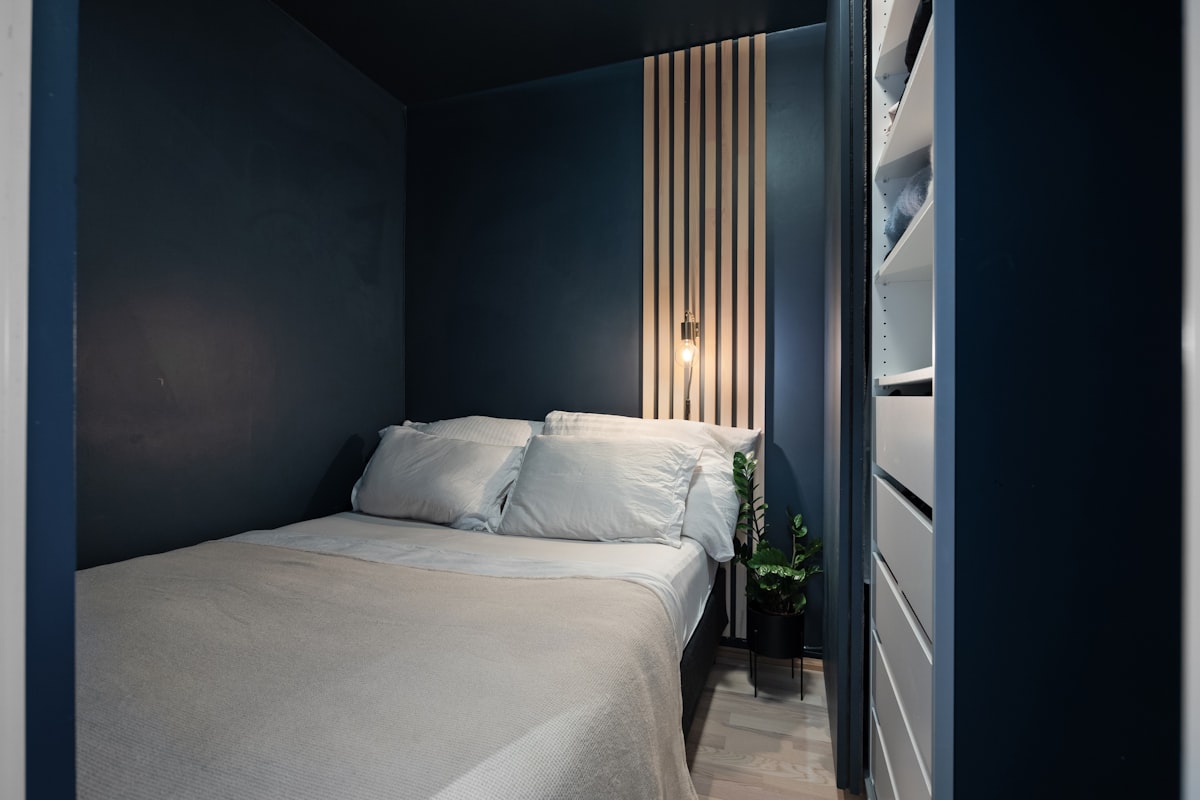 A bedroom with a white bed and blue walls related to Optimizing Space: Beds for Small Rooms