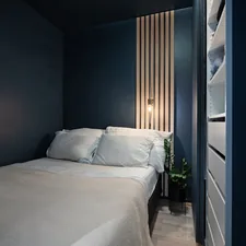 A bedroom with a white bed and blue walls related to Optimizing Space: Beds for Small Rooms