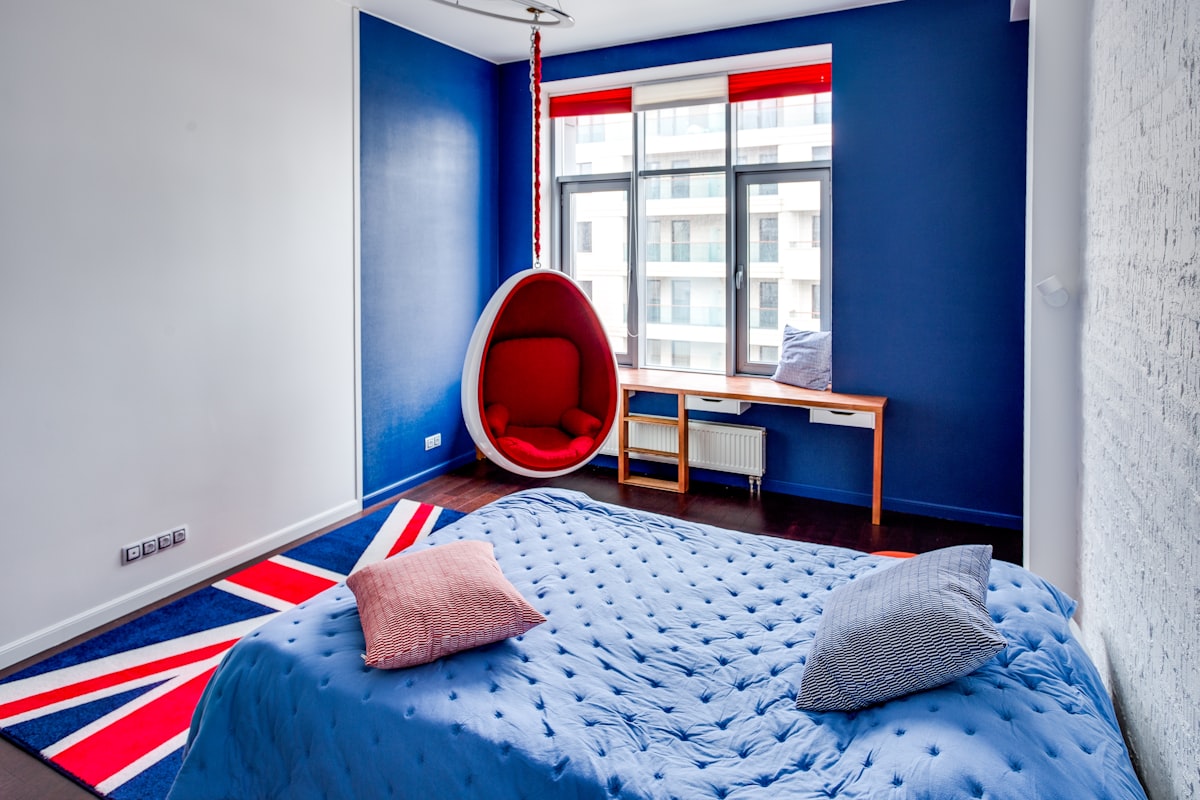 a bedroom with blue walls and a hanging chair related to Patriotic Chic: Red, White, and Blue Bedding for Your Dream Bedroom