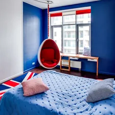 a bedroom with blue walls and a hanging chair related to Patriotic Chic: Red, White, and Blue Bedding for Your Dream Bedroom