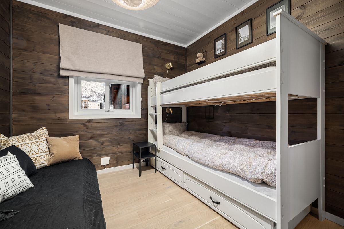 A bedroom with bunk beds and a couch related to Climbing to new heights: The benefits and design options of bunk beds with stairs
