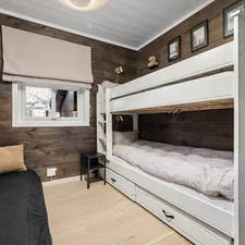 A bedroom with bunk beds and a couch related to Climbing to new heights: The benefits and design options of bunk beds with stairs