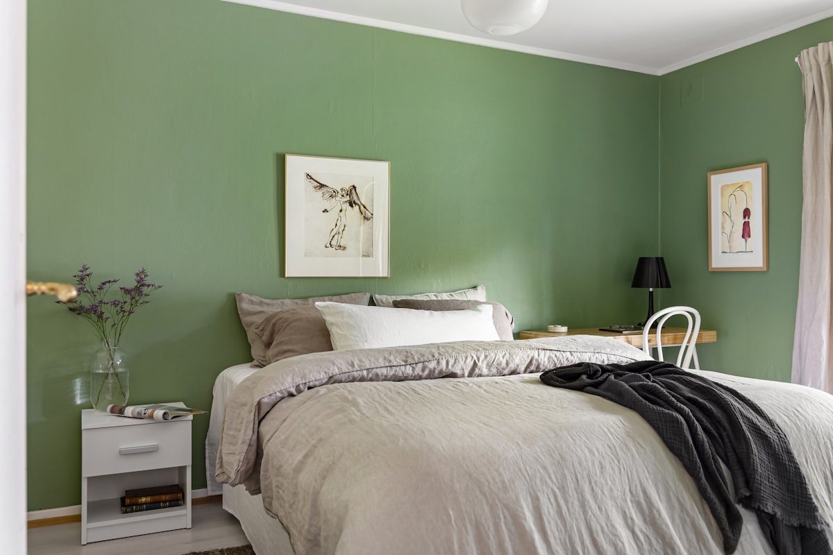 A bedroom with green walls and a white bed related to 8 Dreamy Mint Green Bedding Ideas to Refresh Your Bedroom