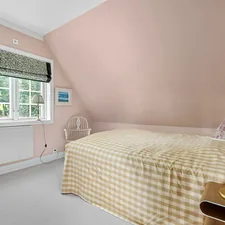 A bedroom with pink walls and a bed related to Unveiling the Enduring Charm of Pink Twin Beds