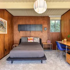 a bedroom with wood paneling and a bed related to Sleek and Sophisticated: The Ultimate Guide to Mid Century Modern Beds