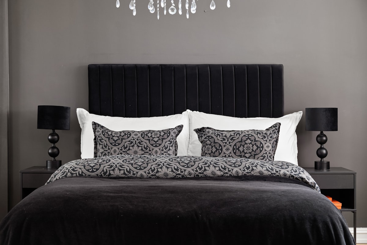 A black and white bedroom with a chandelier related to Black Quilts and Coverlets: Elegant Home Decor