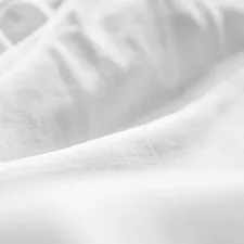 a black and white photo of a bed with white sheets related to Essential Bedding: White Coverlet King